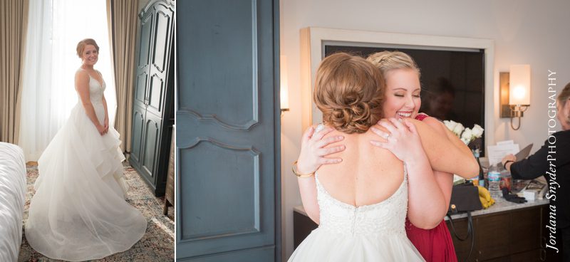 A bride and her mother hugging in front of the mirror.