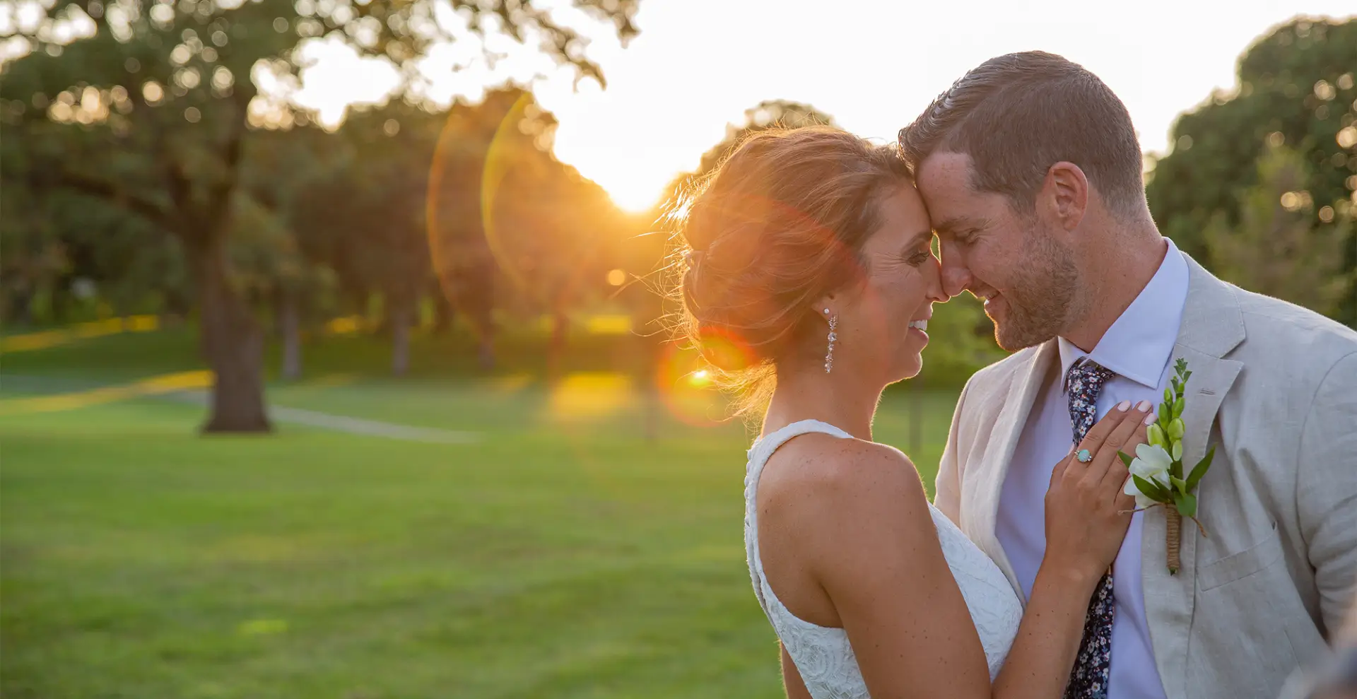 A man and woman are standing in the grass.