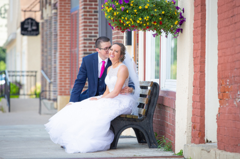 A man and woman sitting on top of a bench.
