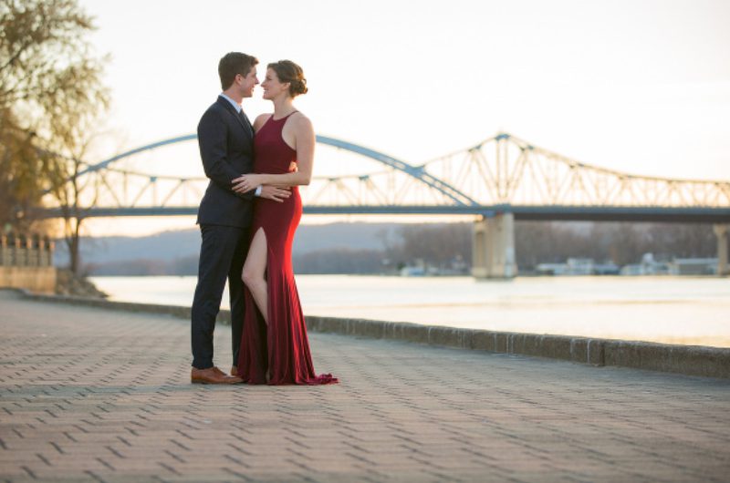 A man and woman in formal wear standing on the sidewalk.
