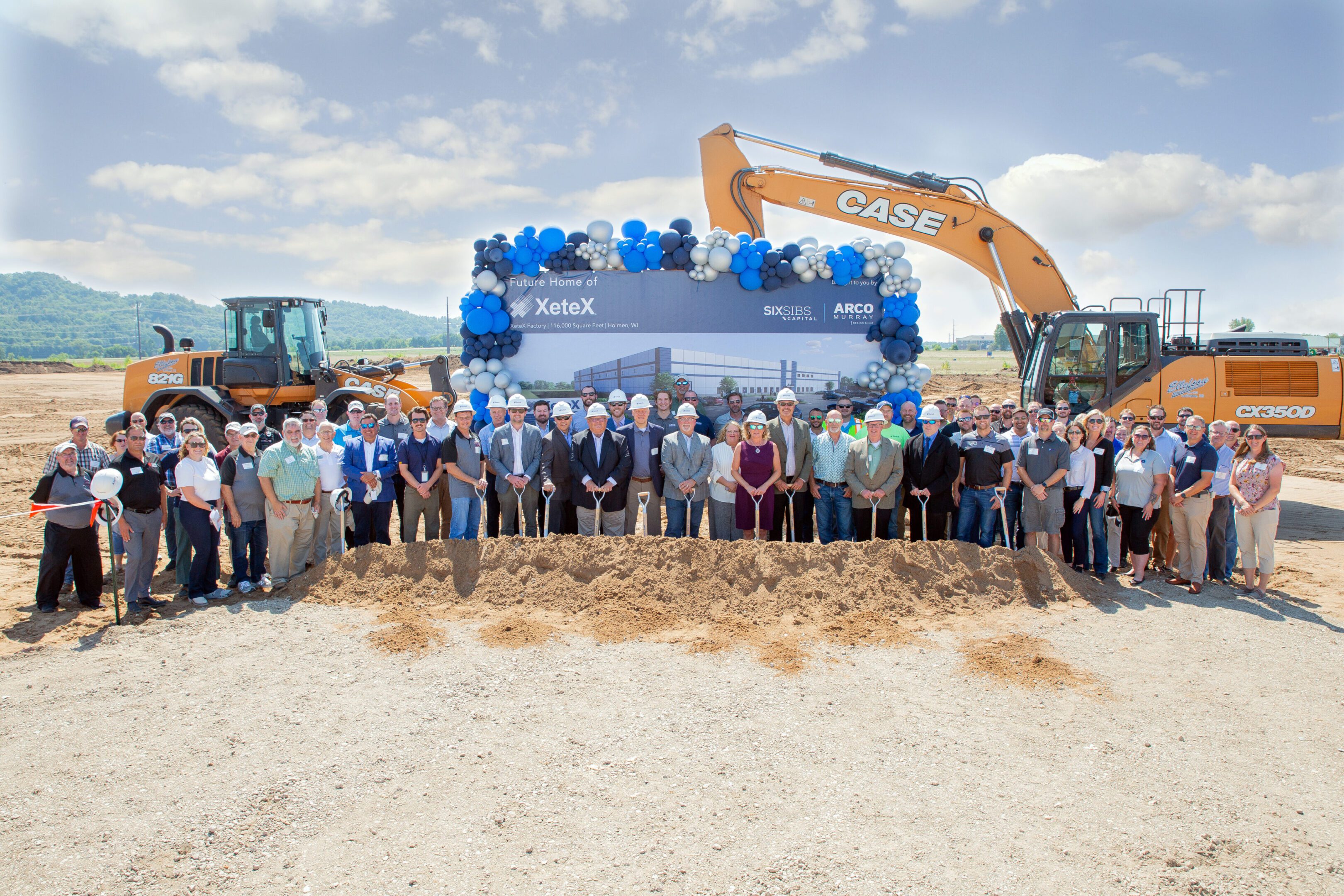 Groundbreaking ceremony group with excavators