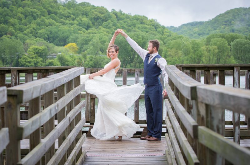 A bride and groom pose for the camera on their wedding day.