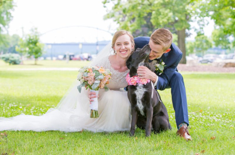 A man and woman posing with their dog.