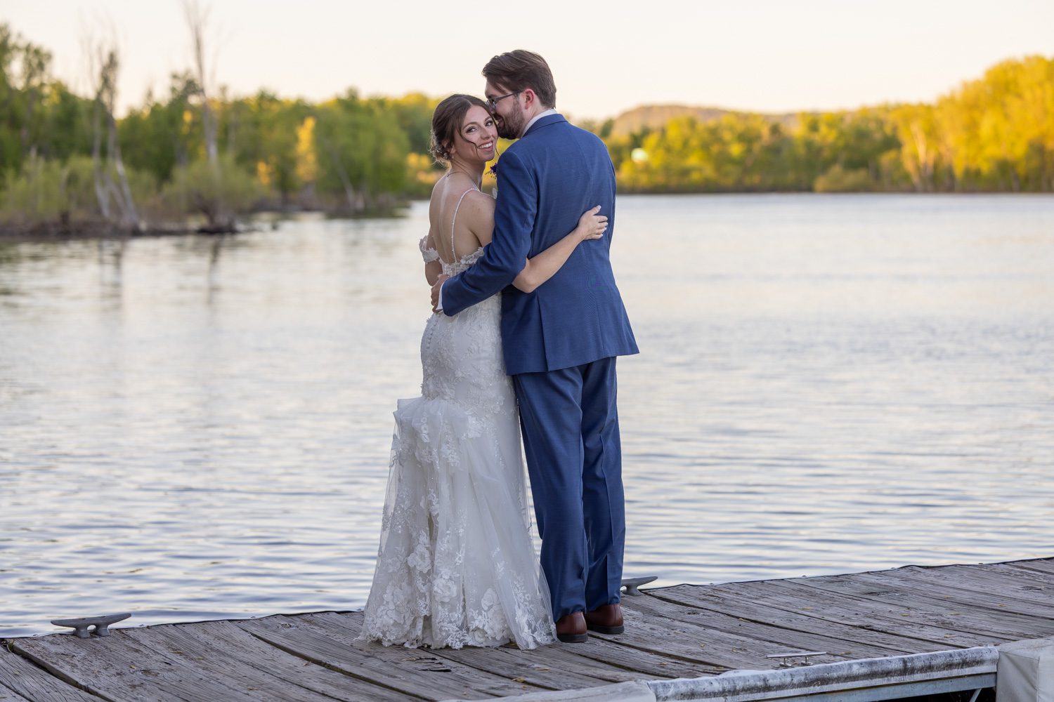 The groom whispering a funny secret to his bride at sunset.
