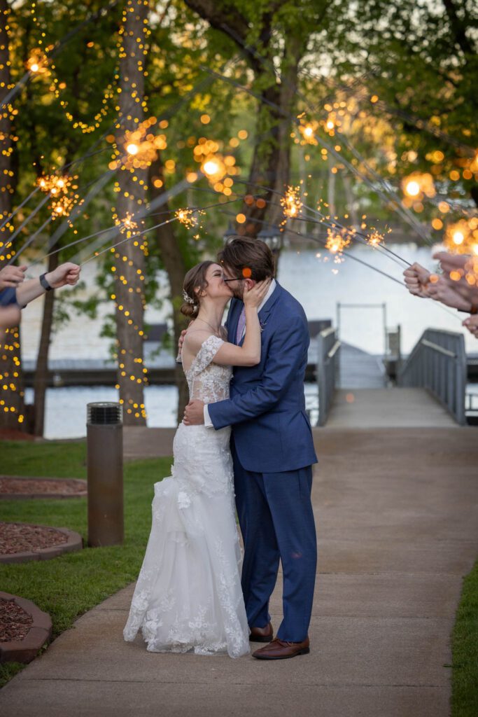 Newlyweds kiss before their special sparkler send-off on wedding day.
