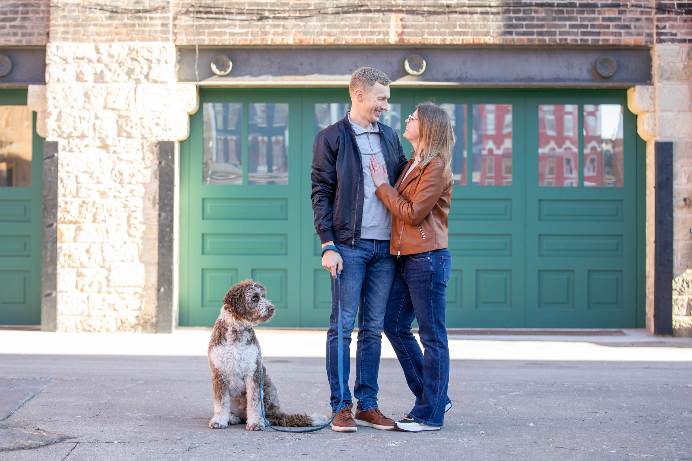 Shaggy rescue dog looks uninterested as his owners hug each other.