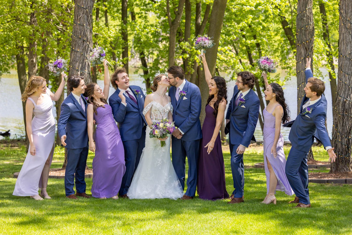 This wedding party can't contain their enthusiasm as the bride and groom share a kiss.