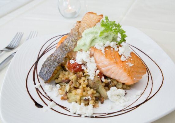 A plate of food with salmon and rice on it.